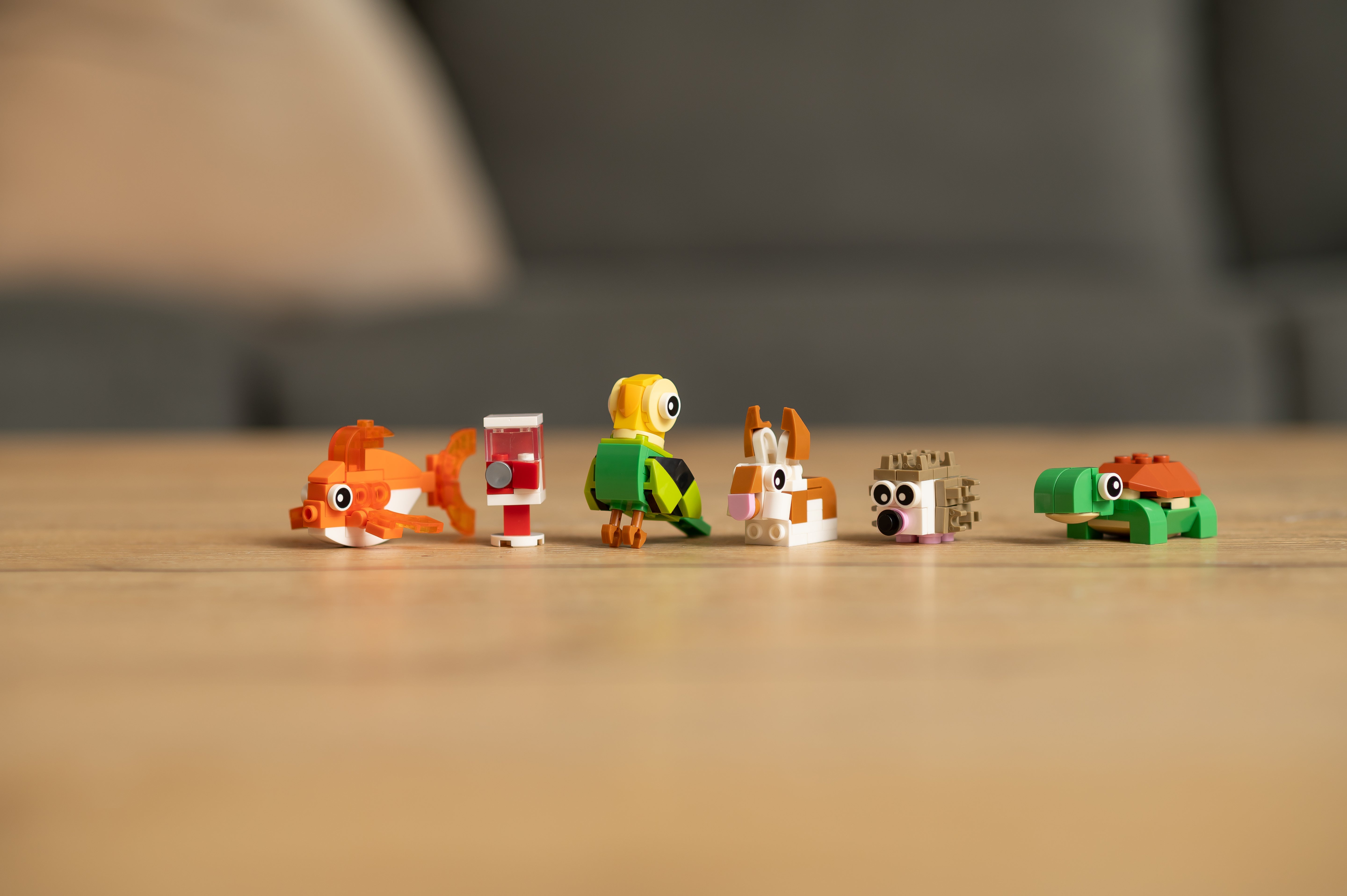 Small toy figures on a wooden surface with a blurred background