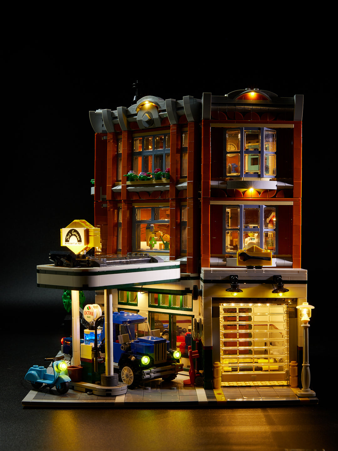LEGO Corner Garage set 10264, fully illuminated with the Brick Loot custom light kit with 116 LEDs to light up the inside, the exerior, the gas station, the scooter, and the tow truck!