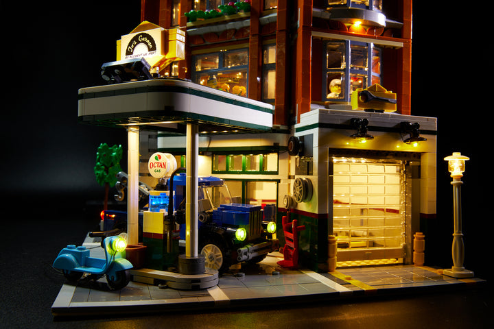Close up of the LEGO Corner Garage set 10264, fully illuminated with the Brick Loot custom light kit with 116 LEDs to light up the inside, the exerior, and the tow truck and vespa!