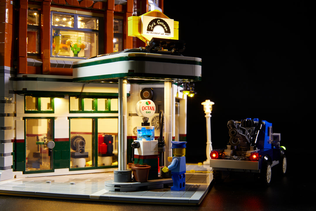 Close up of the gas station of the LEGO Corner Garage set 10264, fully illuminated with the Brick Loot custom light kit with 116 LEDs to light up the inside, the exerior, gas station and the tow truck!