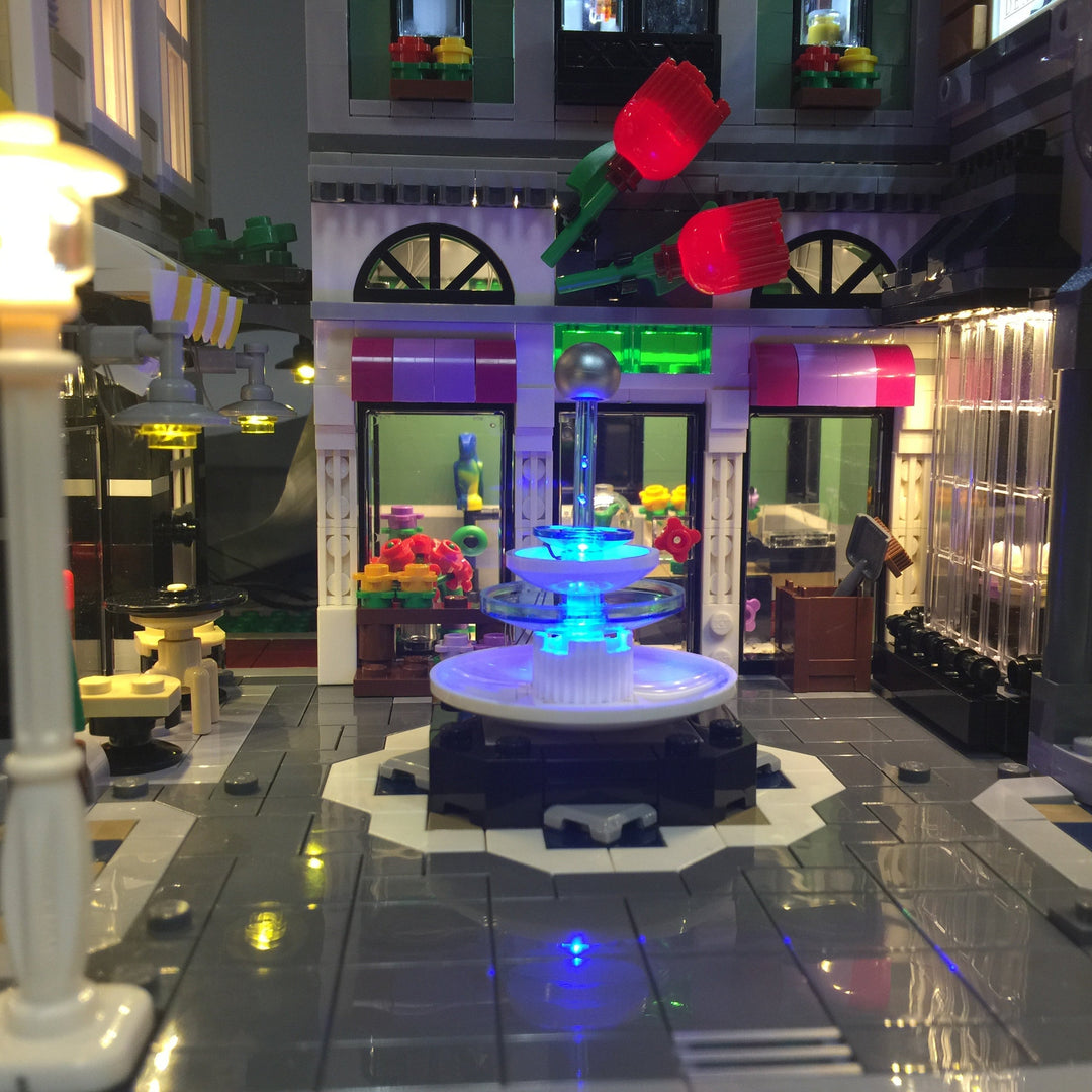 Close up of the LEGO Assembly Square set 10255 with the Brick Loot LED Light Kit installed. Even the fountain is illuminated!