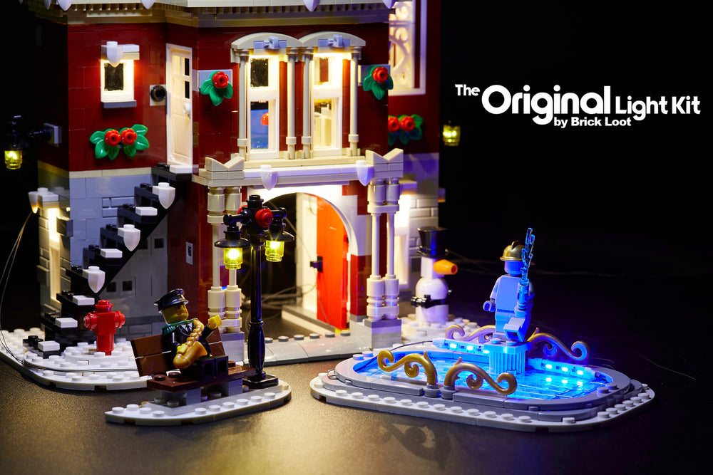 Close up of the  LEGO Winter Village Fire Station set , fully illuminated with the Brick Loot Custom LED Light kit! Beautiful LED lights light up the inside and outside of the Fire Station, black lamp post, and ice skating rink!